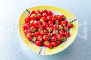 Gelbweißer Teller mit Erdbeeren