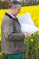Farmer with file folders in rape field