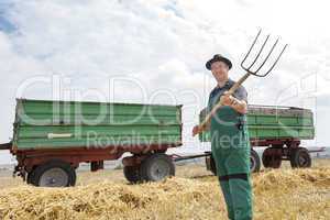 Farmer with pitchfork on the field
