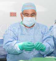 Doctor preparing a catheter for insertion on a patient. Slide Sa