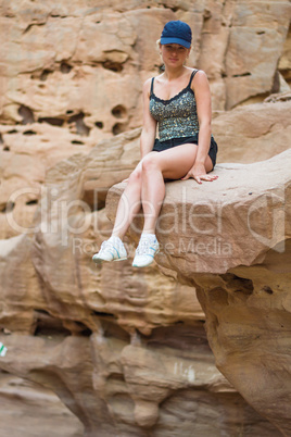 Girl sitting on a rock.