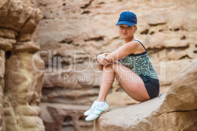 Girl sitting on a rock.