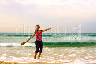 Girl on the beach with a racket.