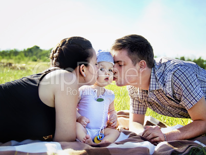 Young parents with baby outdoor in the park