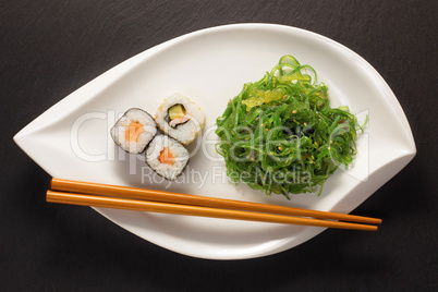 Algensalat mit Maki Sushi und stäbchen