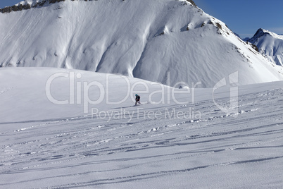 Snowboarder downhill on off piste slope with newly-fallen snow