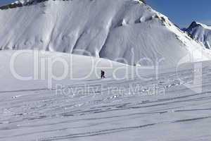 Snowboarder downhill on off piste slope with newly-fallen snow