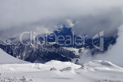 Winter snowy mountains in clouds