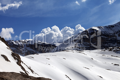 Snow rocks and cloudy blue sky