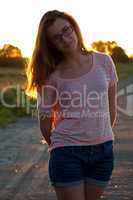 Beautiful teenager girl standing in sunset