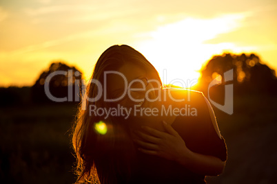 Laughing teenager girl in the light of sunset