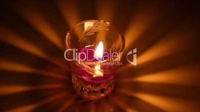 Candle burning in glass candlestick