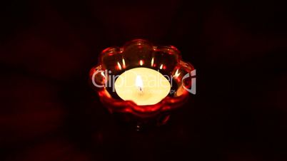 Candle burning in glass candlestick