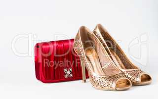 Woman gold shoes on background whit red purse