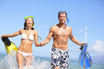 Beach couple fun in water laughing snorkeling
