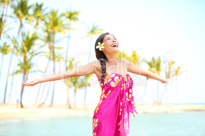 Happy woman praising freedom, palm beach in sarong