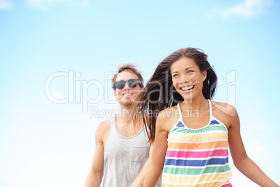 Young couple enjoying beach fun laughing running