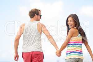 Happy cheerful young trendy couple holding hands