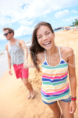 Beach people - young couple holding hands walking