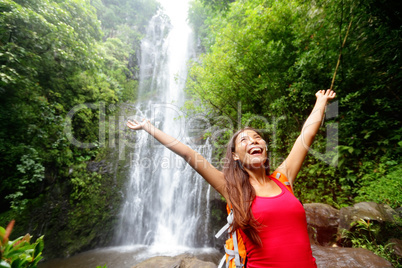 Hawaii woman tourist excited by waterfall