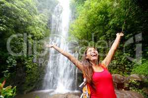 Hawaii woman tourist excited by waterfall