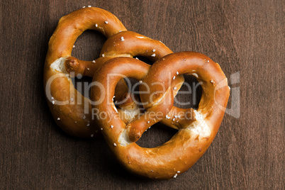 Two typical bavarian pretzel on a brown background