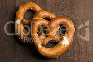 Two typical bavarian pretzel on a brown background