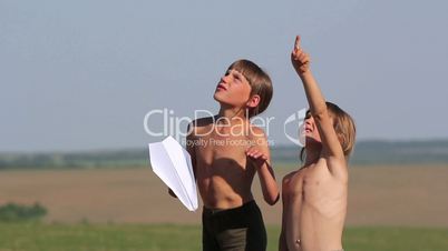 Boys launch a paper airplane.Children playing with a paper airplane.