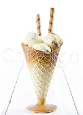 Vanilla ice cream  with wafer in cup on table