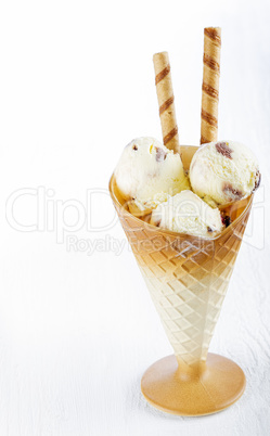 Vanilla ice cream  with wafer in cup on table