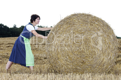 Woman rolling straw bale