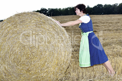 Woman rolling straw bale