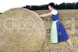 Woman rolling straw bale