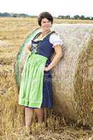 Woman standing on straw bales and enjoys the outdoors