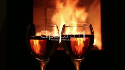 Zwei Weingläser vor einem Kaminfeuer