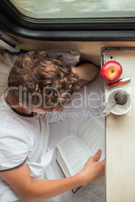 Boy reading a book on the train