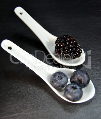 Blueberries and blackberries in black background