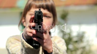 Little boy with a gun in his hand. Juvenile delinquency. A child plays with a gun.