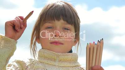 Boy with colored pencils,Child with pencils on sky background, paint in air