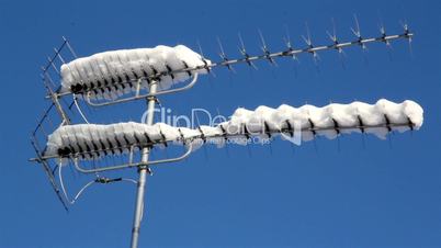 Two antennas covered with snow