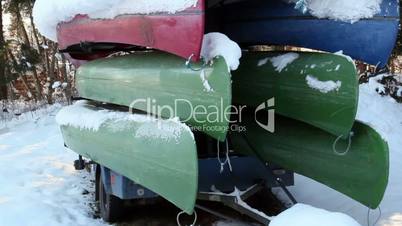 Seven boats piled upside down with snow