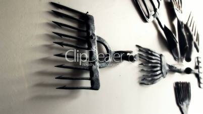 Eight black old fish rakes hanging on the wall