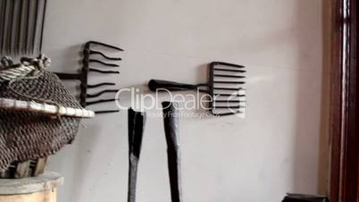 Different kinds of black rakes on the wall