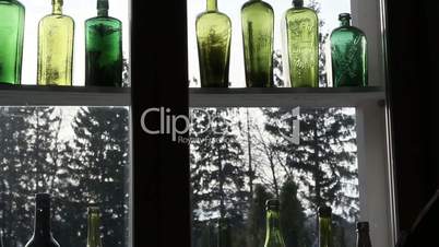 Different kinds of colored bottles on the window