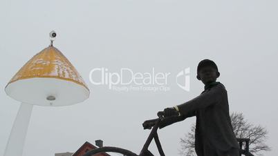 A mans statue in bicycle