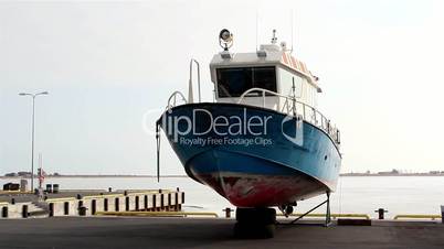 A blue speedboat on standby on the port