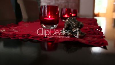 Two red glasses with candles on top of a table
