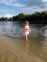 little girl standing in the river