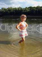 little girl standing in the river