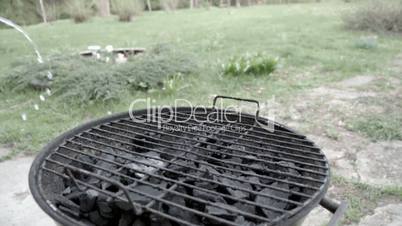 Putting water on coals on a grill